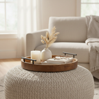 Round wood tray with black handles styled on ottoman in premium living room