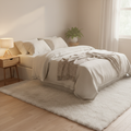 White plush faux fur area rug in cozy bedroom with cream linen bedding and warm natural light