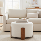 Cream boucle ottoman with walnut legs in front of cream sofa