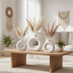 White ceramic donut vases with pampas grass on coffee table